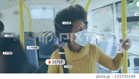Standing woman wearing yellow sweater and mask holding handrail in bus aisle, with digital overlay Standing woman wearing yellow sweater and mask holding handrail in bus aisle, with digital overlay 135350140