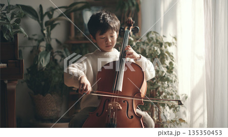 自宅で音に向き合い音楽の基礎を学ぶ子供のチェロ練習風景 自宅で音に向き合い音楽の基礎を学ぶ子供のチェロ練習風景 135350453