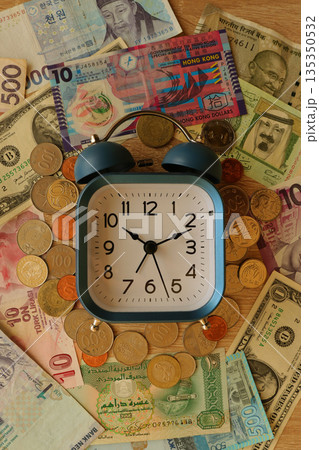 clock and coins on the background of dollars clock and coins on the background of dollars 135350532