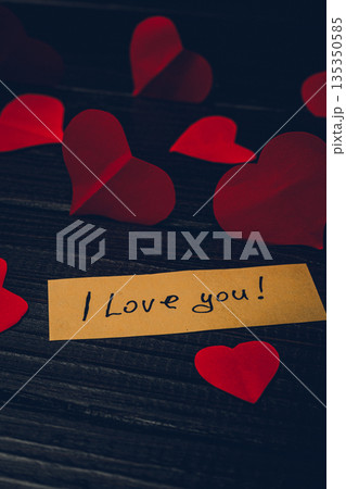 Small red hearts with a note that says I love you on wooden table Small red hearts with a note that says I love you on wooden table 135350585