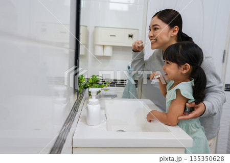 mother teaching girl child to brushing teeth in bathroom mother teaching girl child to brushing teeth in bathroom 135350628