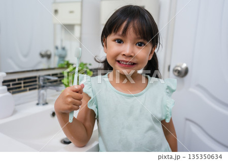 girl child brushing teeth in bathroom 135350634