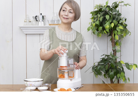 キッチンでフードプロセッサーを使い料理をするシニア女性 キッチンでフードプロセッサーを使い料理をするシニア女性 135350655