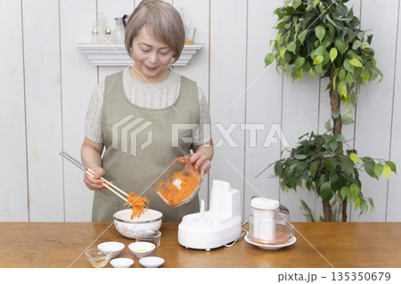 キッチンでフードプロセッサーを使い料理をするシニア女性 キッチンでフードプロセッサーを使い料理をするシニア女性 135350679