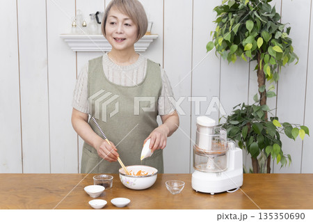 キッチンでフードプロセッサーを使い料理をするシニア女性 キッチンでフードプロセッサーを使い料理をするシニア女性 135350690