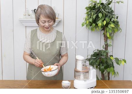 キッチンでフードプロセッサーを使い料理をするシニア女性 キッチンでフードプロセッサーを使い料理をするシニア女性 135350697