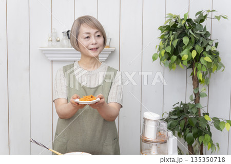 キッチンでフードプロセッサーを使い料理をするシニア女性 キッチンでフードプロセッサーを使い料理をするシニア女性 135350718