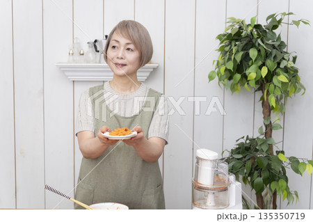 キッチンでフードプロセッサーを使い料理をするシニア女性 キッチンでフードプロセッサーを使い料理をするシニア女性 135350719