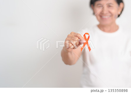 Elderly with Orange Ribbon for September Leukemia, March Kidney cancer day, Multiple Sclerosis, Self Injury Awareness month, November Complex Regional Pain Syndrome, CRPS, COPD disease concept 135350898