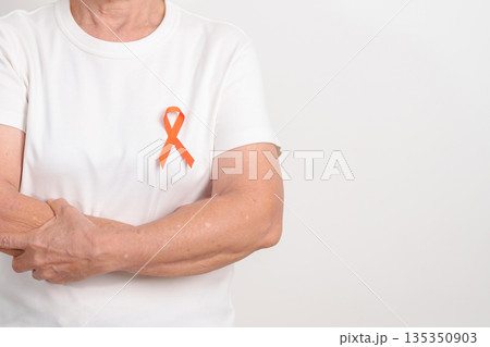 Elderly with Orange Ribbon for September Leukemia, March Kidney cancer day, Multiple Sclerosis, Self Injury Awareness month, November Complex Regional Pain Syndrome, CRPS, COPD disease concept 135350903