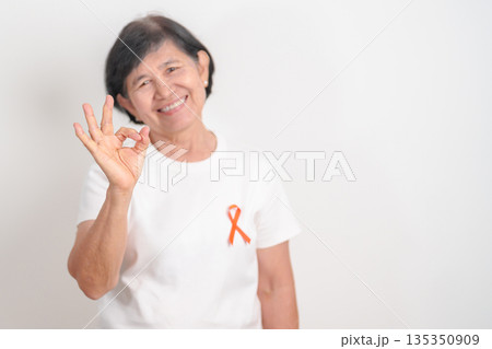 Elderly with Orange Ribbon for September Leukemia, March Kidney cancer day, Multiple Sclerosis, Self Injury Awareness month, November Complex Regional Pain Syndrome, CRPS, COPD disease concept 135350909