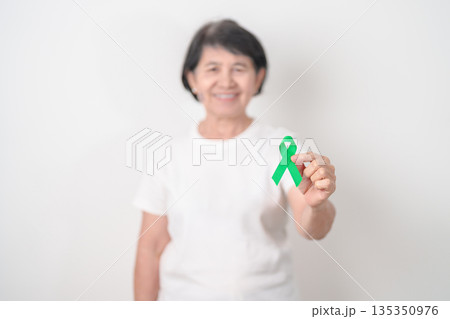 Elderly with Green Ribbon for concept of March world Bipolar disorder day, Cerebral Palsy Awareness month, kidney disease Cancer and Traumatic Brain Injury, TBI. Healthcare and world cancer day Elderly with Green Ribbon for concept of March world Bipolar disorder day, Cerebral Palsy Awareness month, kidney disease Cancer and Traumatic Brain Injury, TBI. Healthcare and world cancer day 135350976