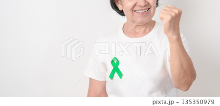 Elderly with Green Ribbon for concept of March world Bipolar disorder day, Cerebral Palsy Awareness month, kidney disease Cancer and Traumatic Brain Injury, TBI. Healthcare and world cancer day Elderly with Green Ribbon for concept of March world Bipolar disorder day, Cerebral Palsy Awareness month, kidney disease Cancer and Traumatic Brain Injury, TBI. Healthcare and world cancer day 135350979