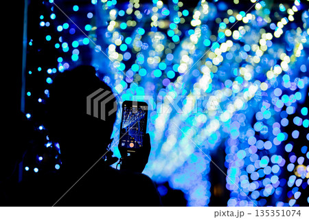 【愛知県飛島村】とびしま宵あかり　風鈴とイルミネーションの絶景をスマホで撮影する女性 135351074