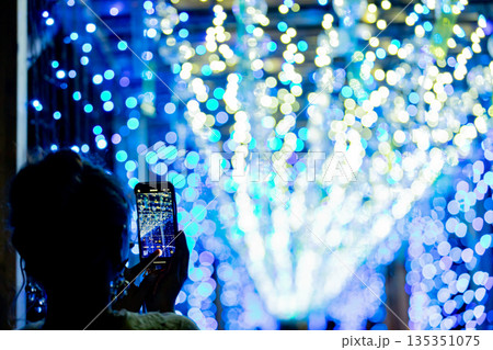 【愛知県飛島村】とびしま宵あかり　風鈴とイルミネーションの絶景をスマホで撮影する女性 135351075