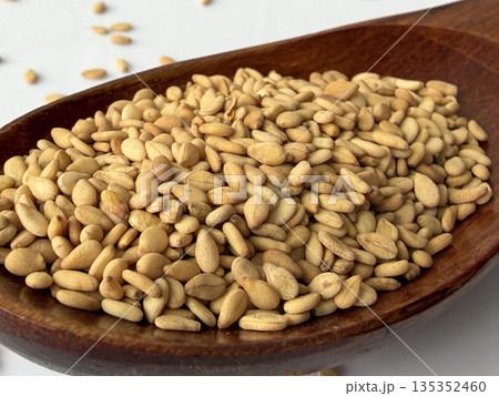 Macro Close-Up of Sesame Seeds in Wooden Spoon on Light Background Macro Close-Up of Sesame Seeds in Wooden Spoon on Light Background 135352460