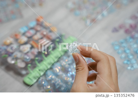 シール帳に3Dシールを貼る女の子の手元 135352476