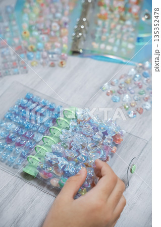 シール帳に3Dシールを貼る女の子の手元 シール帳に3Dシールを貼る女の子の手元 135352478