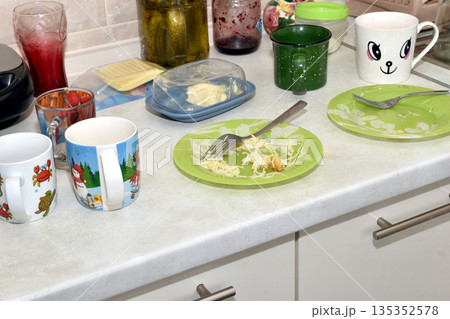 Dirty dishes are on the kitchen table. Dirty dishes are on the kitchen table. 135352578