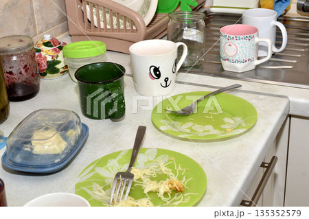 Dirty dishes are on the kitchen table. 135352579