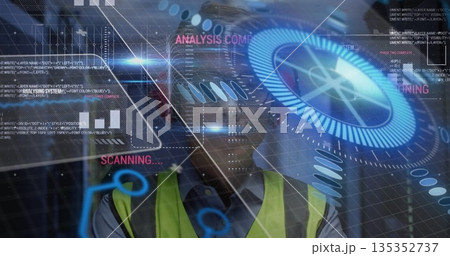 Monitoring engineer viewing holographic interface at industrial site, wearing helmet, safety vest 135352737