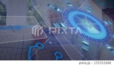 Reaching senior woman touching holographic controls on sofa in living room, with graphs Reaching senior woman touching holographic controls on sofa in living room, with graphs 135352886