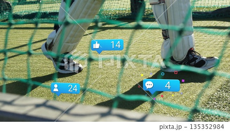 Cricketer performing batting drills in net cage with white pads, two-tone shoes, social icons Cricketer performing batting drills in net cage with white pads, two-tone shoes, social icons 135352984