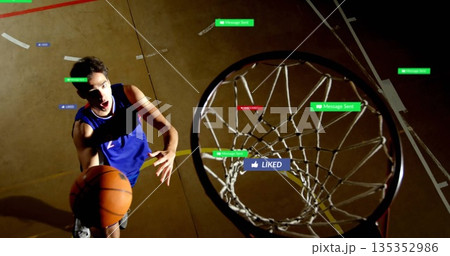 Leaping male basketball player wearing blue jersey on wooden court, with hoop and floating labels Leaping male basketball player wearing blue jersey on wooden court, with hoop and floating labels 135352986