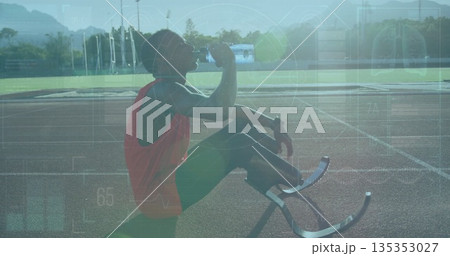 Kneeling teenage Paralympic runner drinking from water bottle on red track, with blades, copy space Kneeling teenage Paralympic runner drinking from water bottle on red track, with blades, copy space 135353027