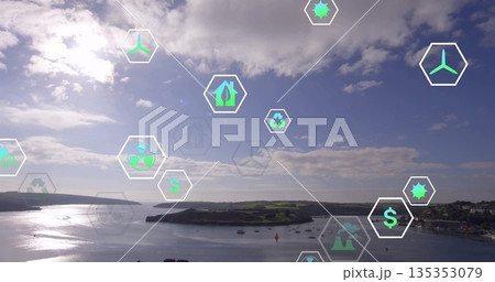 Displaying bay with boats reflecting sunlight on water at peninsula, digital sustainability icons 135353079