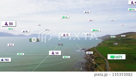 Floating digital overlay icons hovering over narrow coastal road by rocky shoreline, green fields 135353082