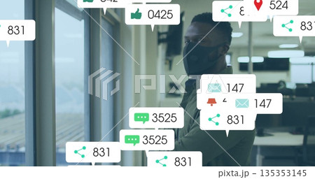 Standing masked man checking floating notification icons by window, monitors in office, copy space Standing masked man checking floating notification icons by window, monitors in office, copy space 135353145