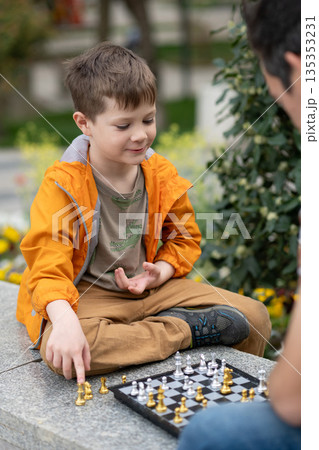 Boy playing chess outdoor. Learning strategic game. Education. Boy playing chess outdoor. Learning strategic game. Education. 135353231