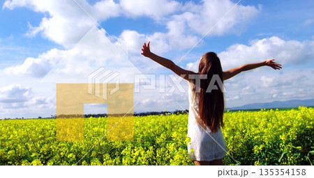 Standing woman in white sleeveless dress stretching arms in yellow blooms, with house arrow overlay 135354158