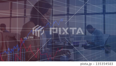 Typing woman wearing blazer working on laptop in open-plan office, with financial graphs overlay Typing woman wearing blazer working on laptop in open-plan office, with financial graphs overlay 135354583