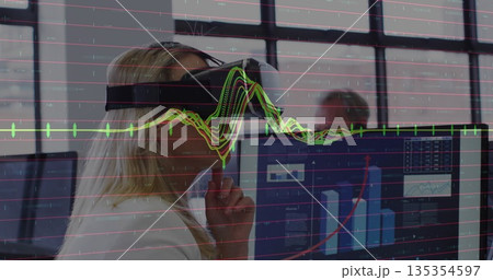 Woman wearing blazer and VR headset analyzing data using dual monitors at office desk, copy space Woman wearing blazer and VR headset analyzing data using dual monitors at office desk, copy space 135354597