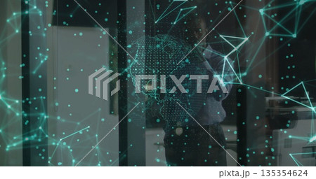 Businessman projecting digital network overlay with globe and nodes in office with glass partition 135354624