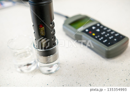 pH electrode placed in a glass of water, concept of water quality testing and analysis. 135354993
