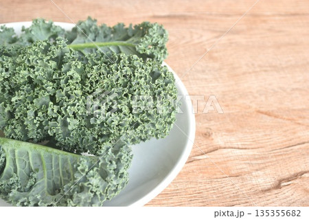 fresh green Curly Kale vegetable salad with drop of water arranging on plate 135355682