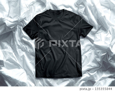 Minimalist Flat Lay of a Blank Black Crew Neck T-shirt on White Crumpled Fabric Background, High-Quality Apparel Mockup Template for Fashion Branding and Custom Logo Presentation. 135355844