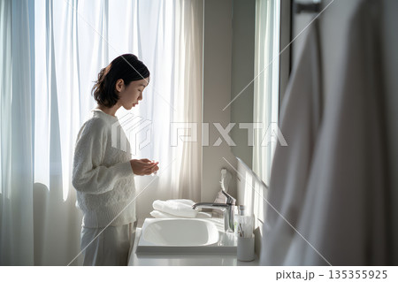 鏡を見ながら肌をチェックする日本人女性。スキンケアと美容習慣のイメージ 135355925