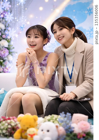 キスアンドクライで得点を待つ女子フィギュアスケート選手とコーチ 135356006