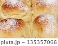 Close up of fresh sweet buns dusted with white powdered sugar. 135357066