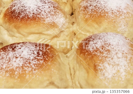Close up of fresh sweet buns dusted with white powdered sugar. Close up of fresh sweet buns dusted with white powdered sugar. 135357066
