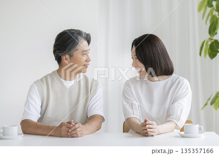 向き合って微笑む50代の夫婦 135357166