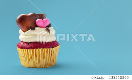 Red velvet cupcake with cream cheese frosting and heart chocolate valentines day decorated on blue background 135358899