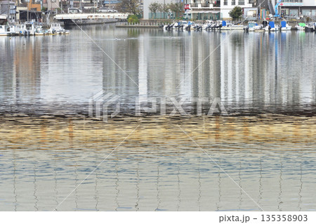 京葉道路が映り込む海老川河口に置かれたプレジャーボート 135358903