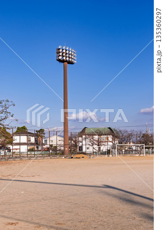 放課後の静かな土のグラウンドとサッカーゴール、日本のアニメ風の風景（部活・ノスタルジー） 135360297