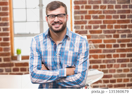 African American man standing in loft office by white desk holding colored pens and succulent African American man standing in loft office by white desk holding colored pens and succulent 135360679