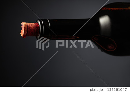 An almost opened bottle of red wine. 135361047